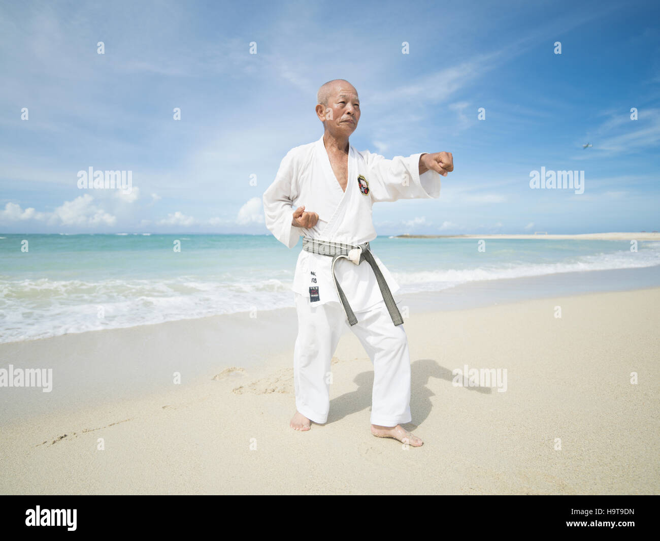 Elderly black belt karate master training on the beach in Okinawa