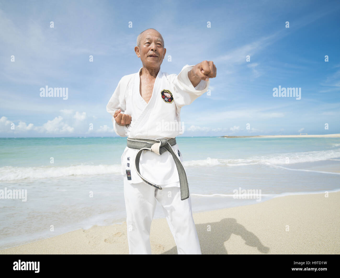 Elderly black belt karate master training on the beach in Okinawa