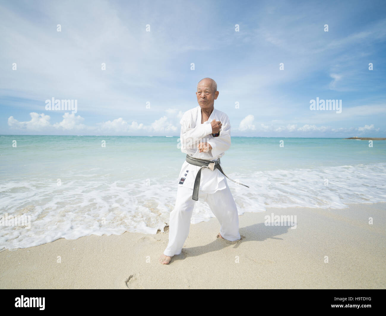 Elderly black belt karate master training on the beach in Okinawa