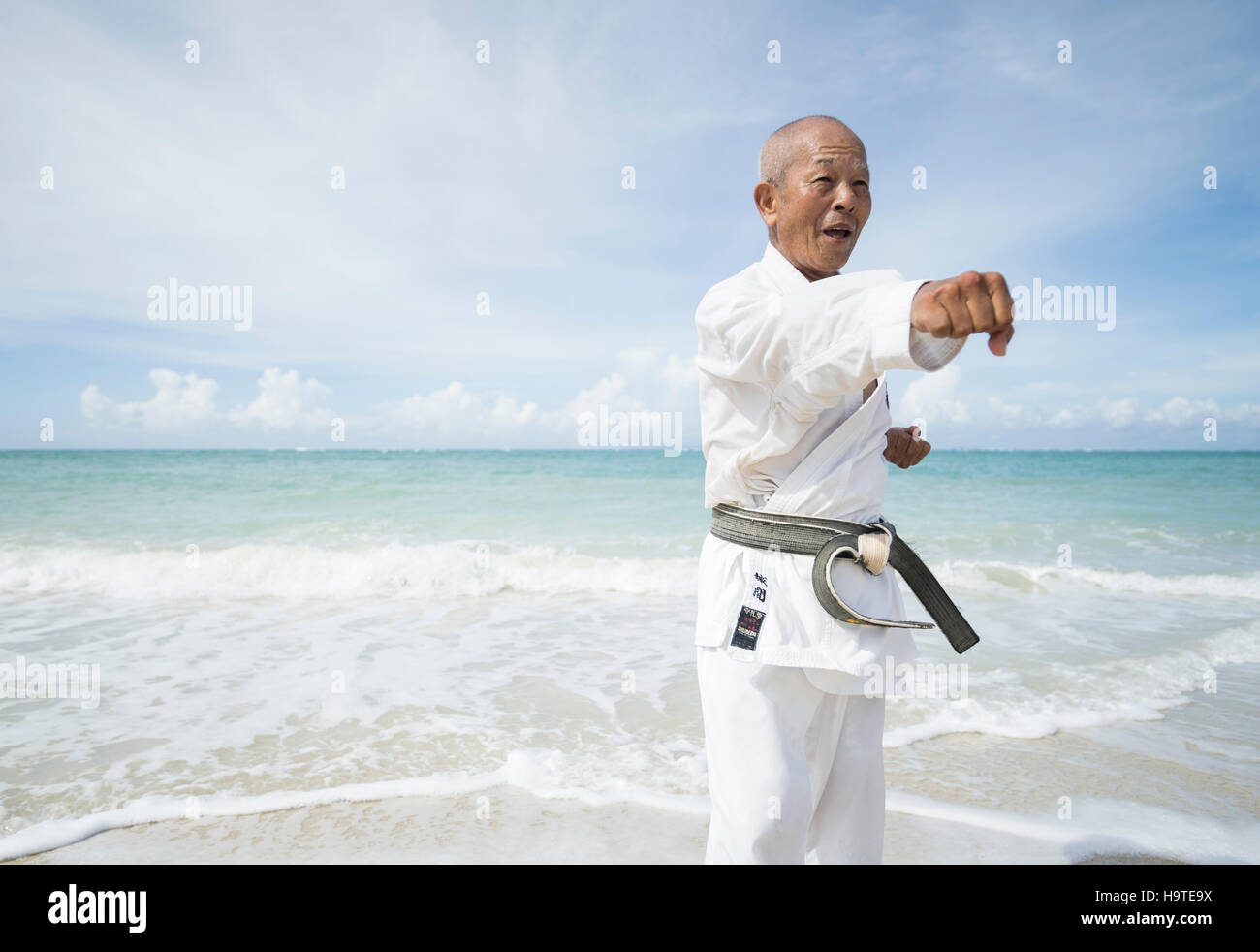 Elderly black belt karate master training on the beach in Okinawa