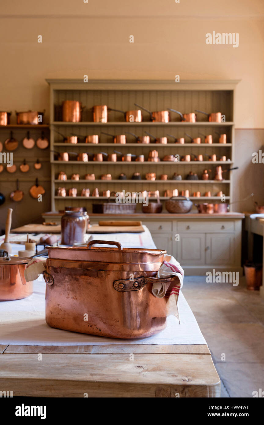 The Kitchen at Attingham Park, Shropshire. The elm-topped table and dresser are filled with the copper batterie de cuisine. Stock Photo