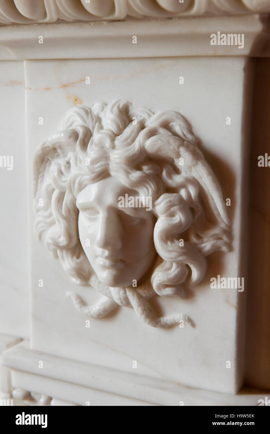 Close view of the carved head of Medusa on the fireplace in the Inner Library at Attingham Park, Shropshire. Stock Photo