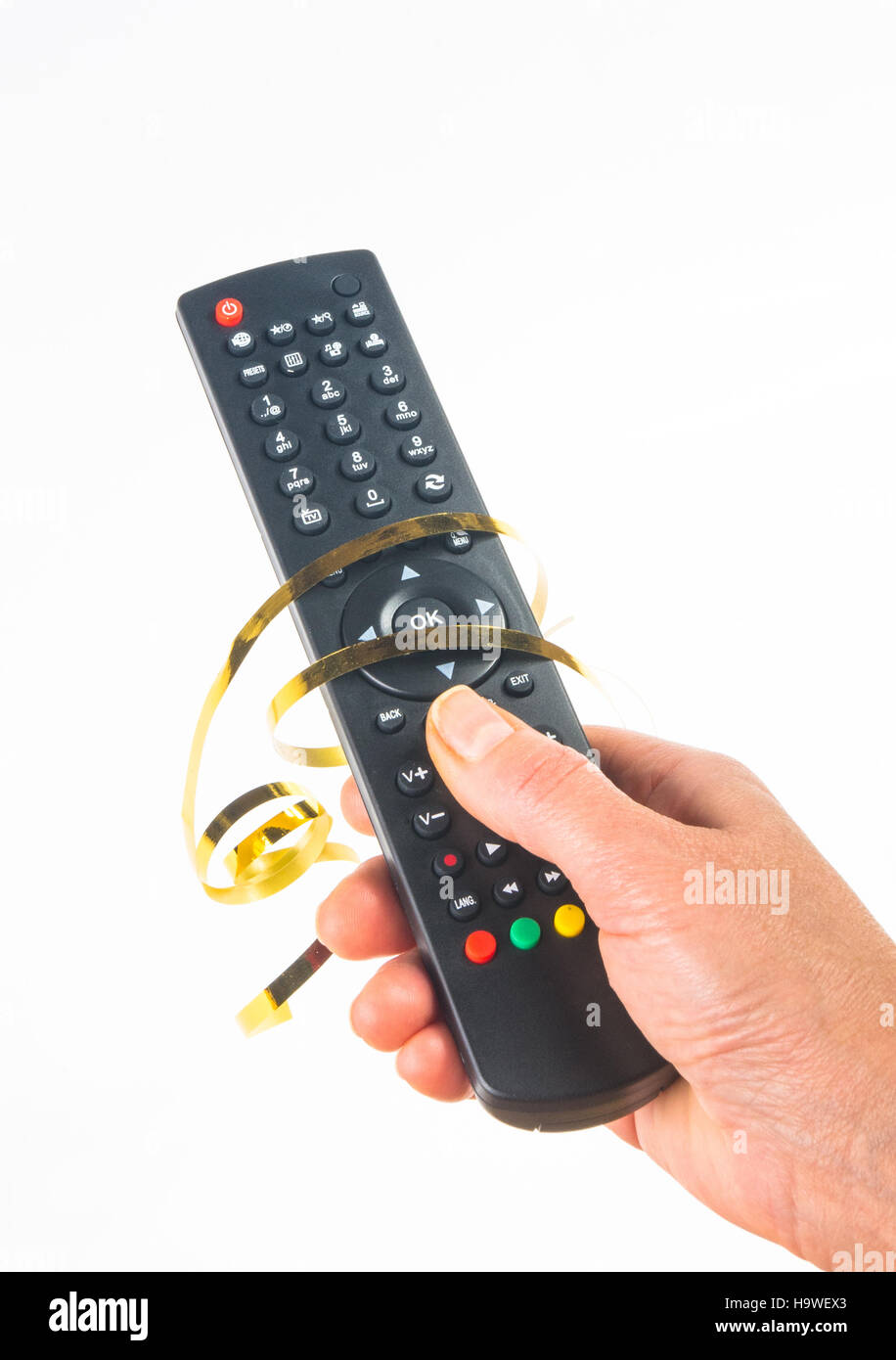 hand holding a remote control in a festive gold ribbon on white