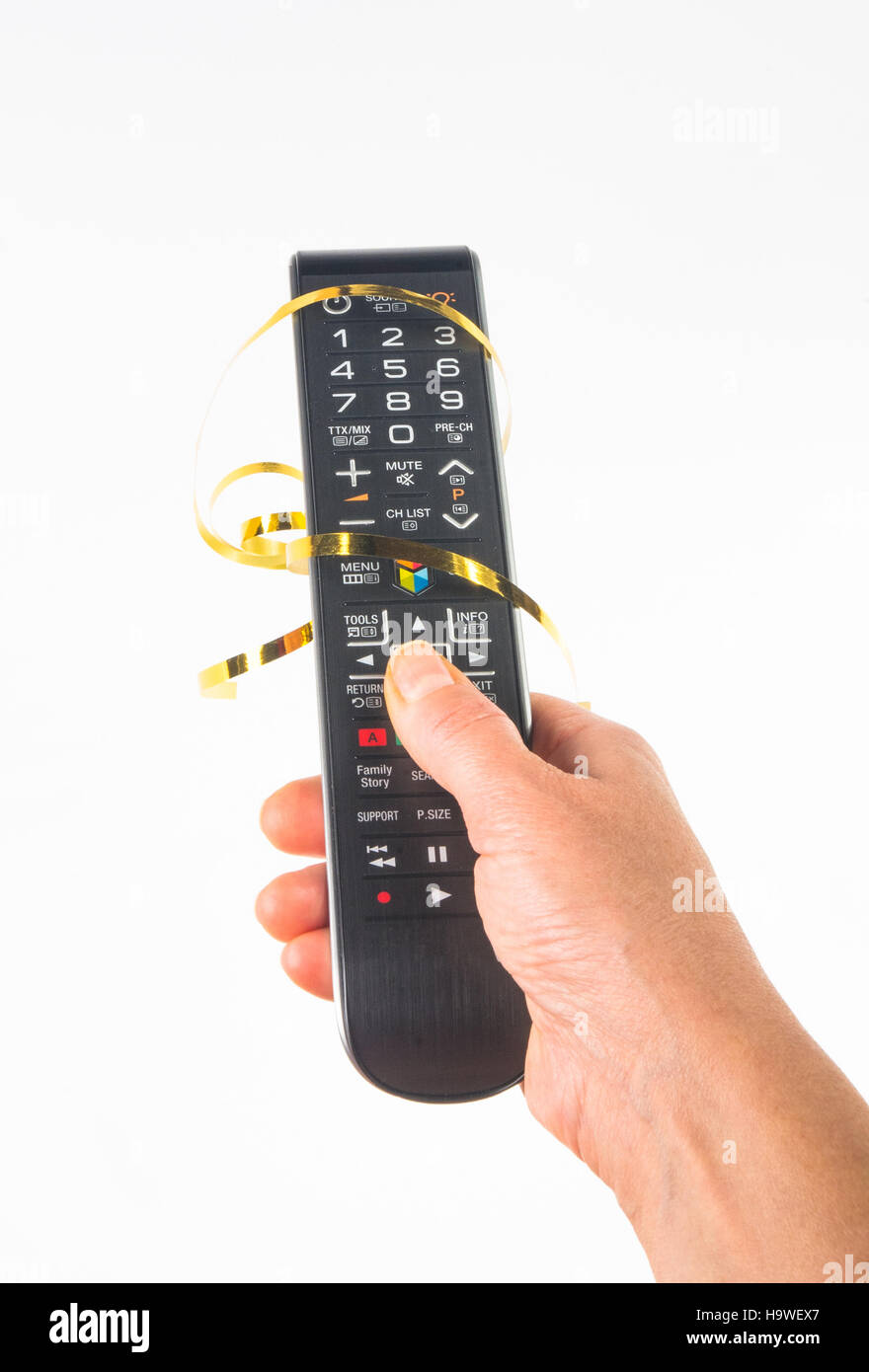 hand holding a remote control in a festive gold ribbon on white
