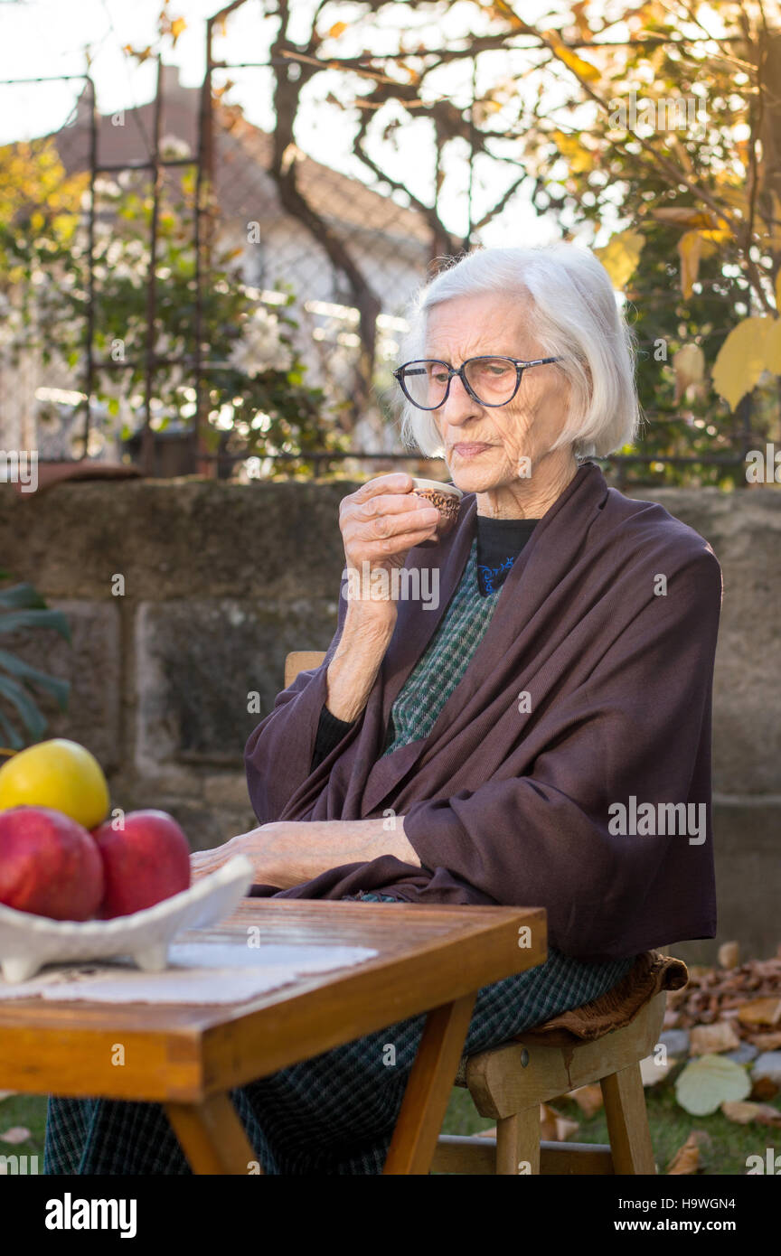 Senior woman having cup of coffee outdoors Stock Photo