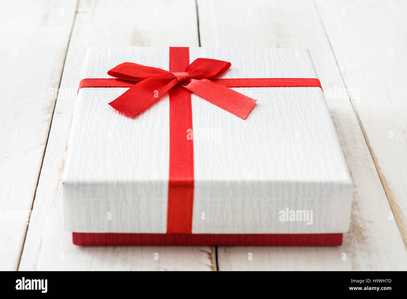 White gift box on white wooden table.closeup Stock Photo - Alamy