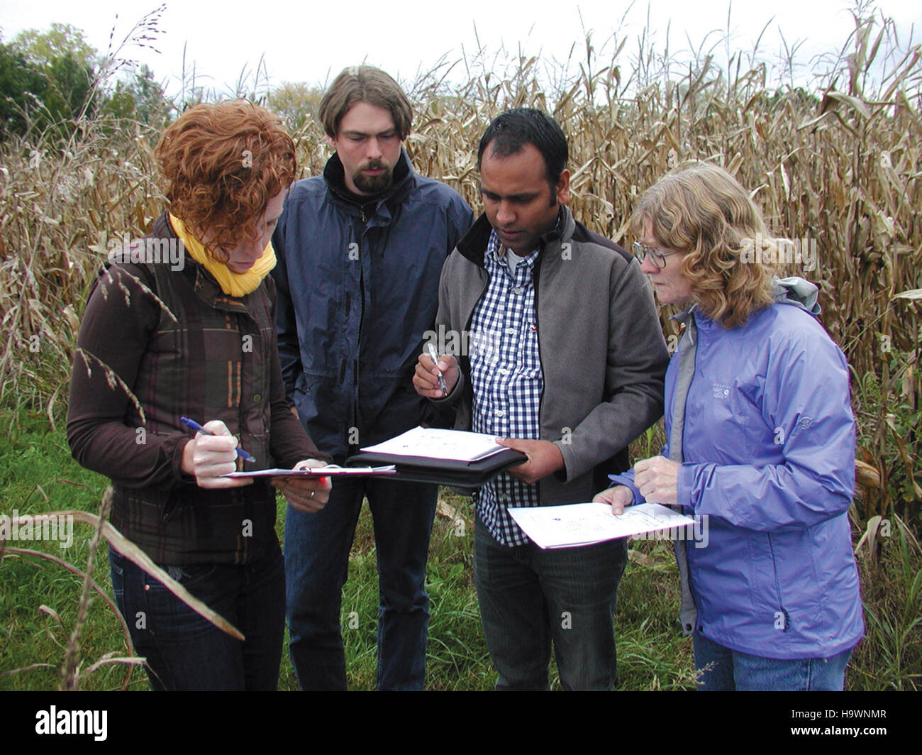 usdagov 23450303460 Dr. Morton and her colleagues looking at the layout of one of the more than 35 field sites they are gathering data on Stock Photo