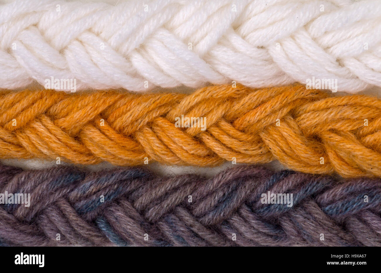 Braided wool yarn swatches colored by henna and indigo and control white sample Stock Photo