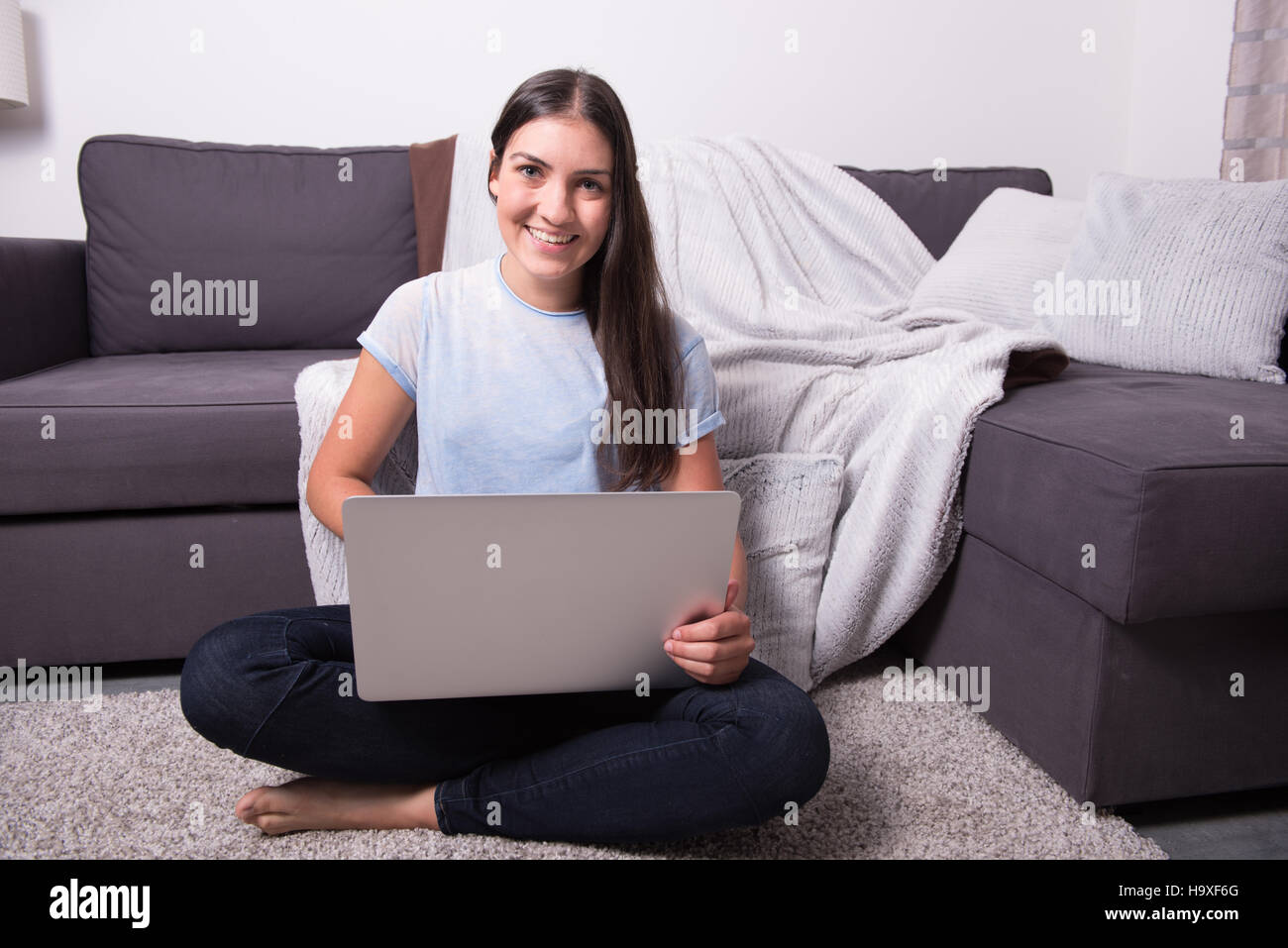 Young attractive woman sitting on the floor and working with computer ...