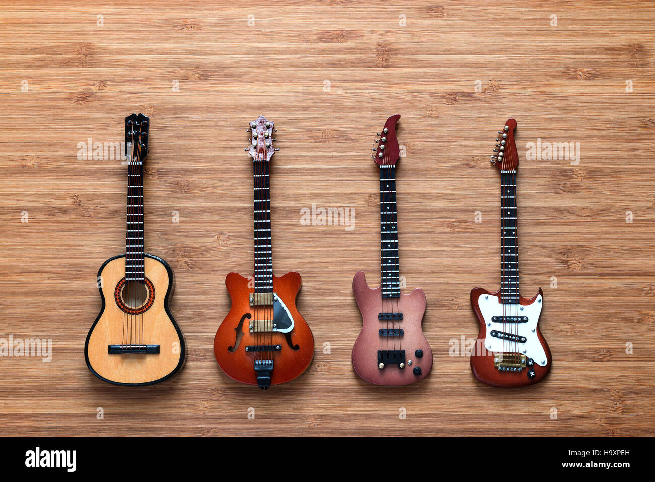 Set of four guitars on a wooden background. Stock Photo