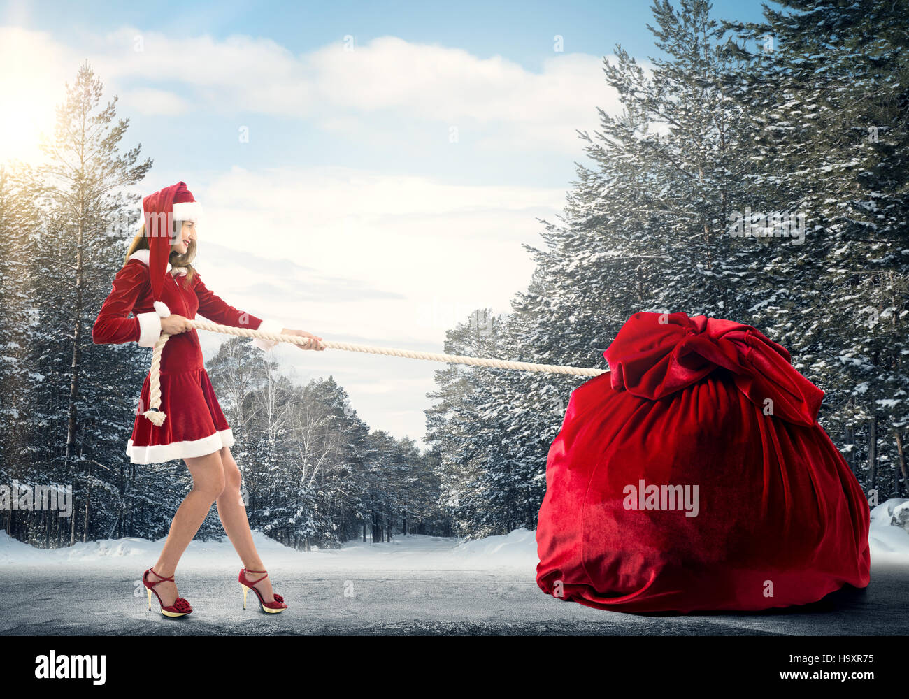Santa woman pulling huge red gifts bag Stock Photo - Alamy