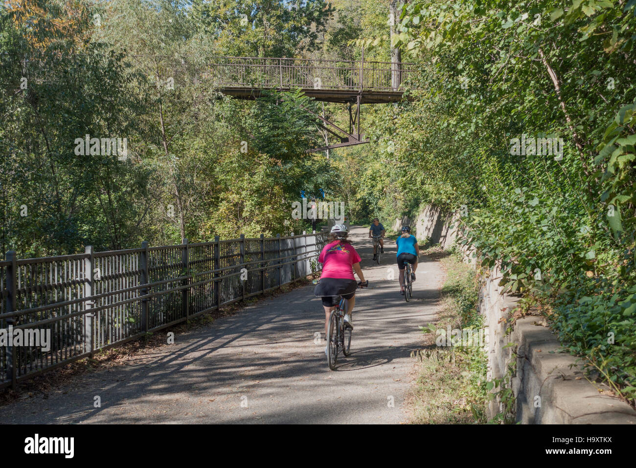 Bicyclers riding along the Minnehaha Trail under a pedestrian walkway. Minneapolis Minnesota MN USA Stock Photo