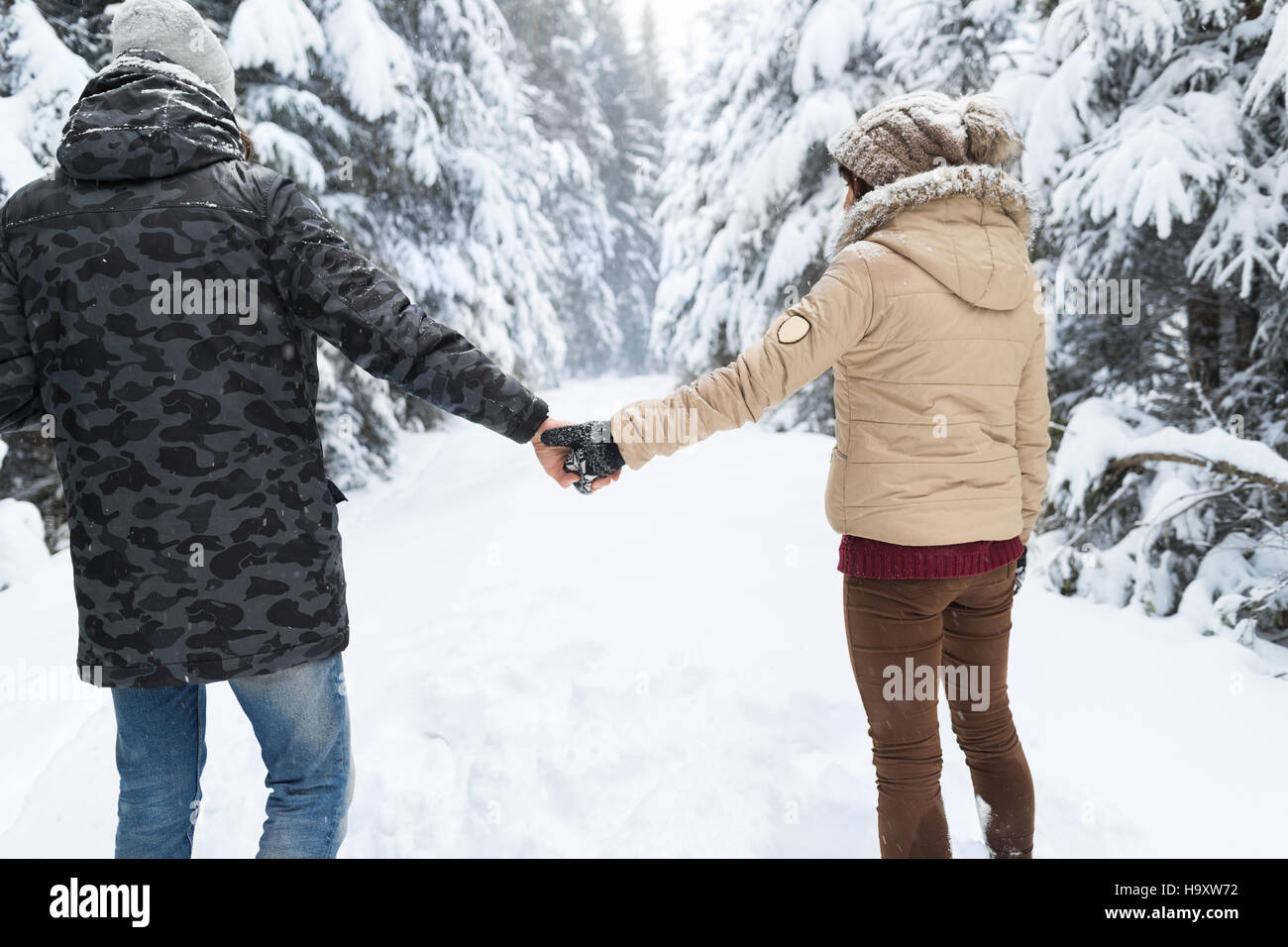 Young Couple Walking In Snow Forest Outdoor Man And Woman Holding Hands ...