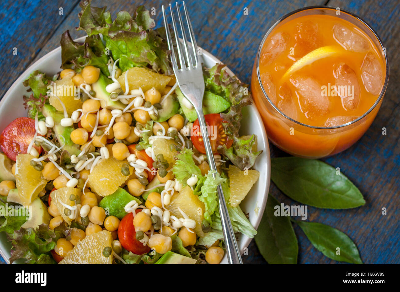 Healthy green salad with orange, avocado, tomatoes, sprouts of mung