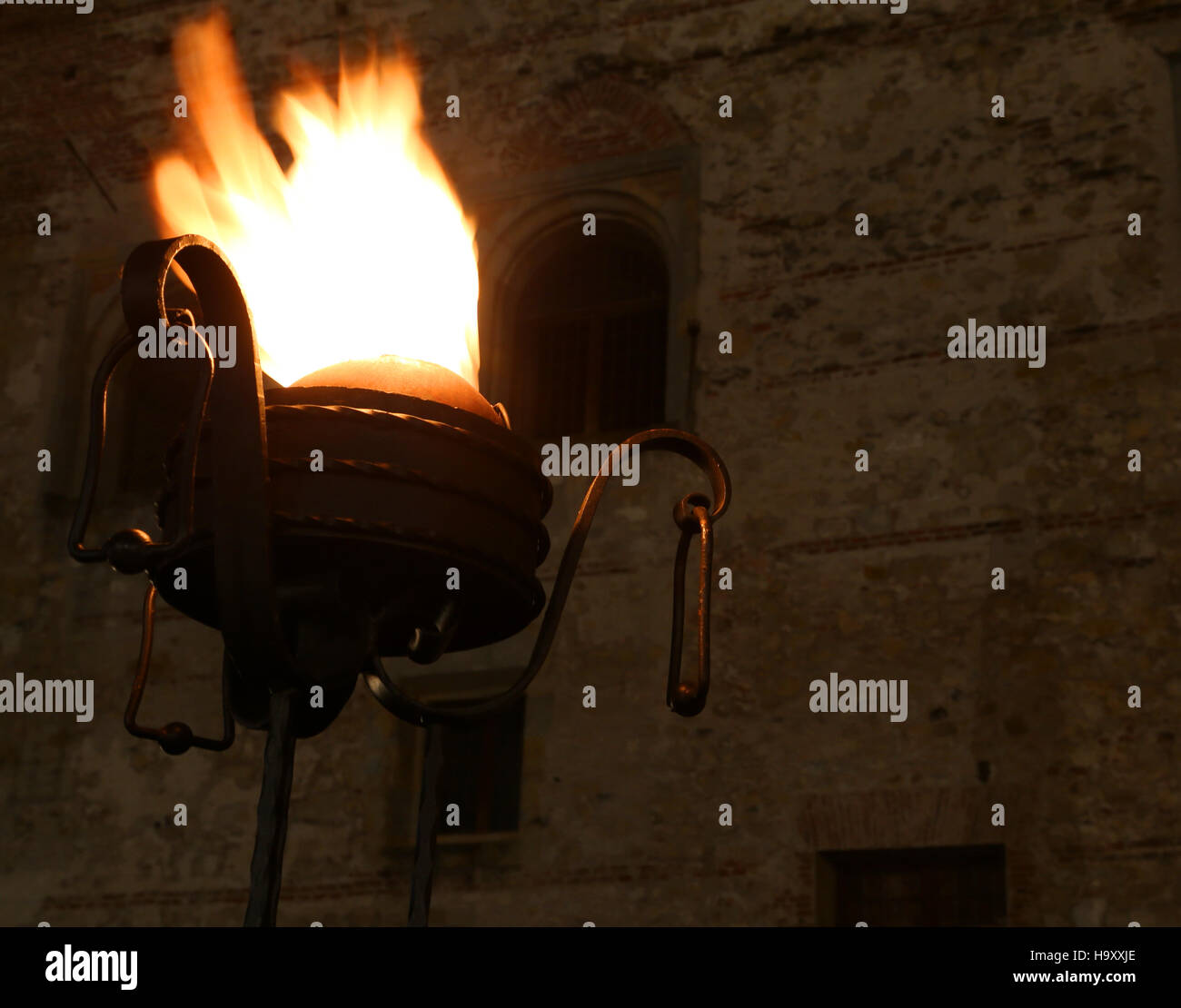 burning ancient oil lamp at the entrance of the medieval castle Stock