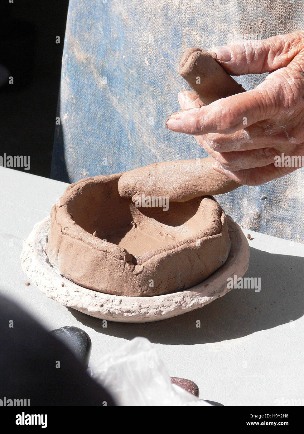 Visitors to Bandelier National Park experience pottery making demonstrations, highlighting ancient craft traditions and the park's cultural heritage. Stock Photo