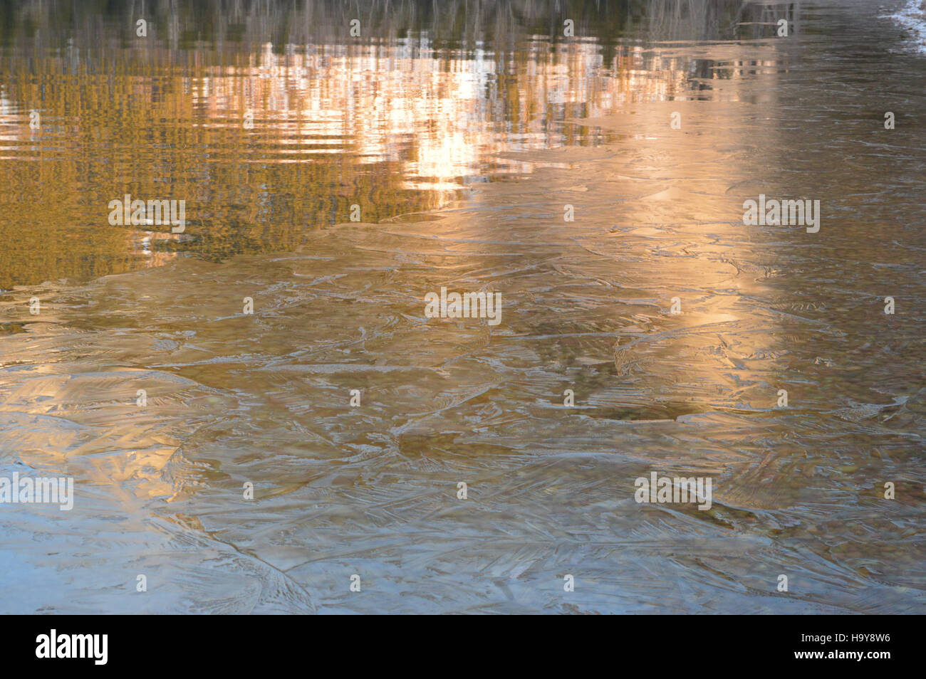 The image captures the serene ice-covered surface of Lake McDonald in ...