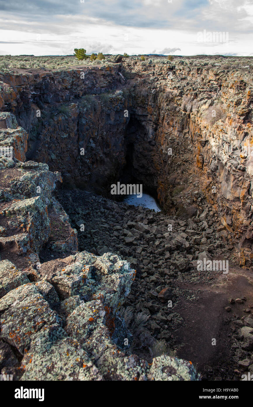 A view from King's Bowl in the Craters of the Moon National Monument in Idaho. The site, part of the Great Rift Expedition, is known for its dramatic volcanic landscapes and challenging backpacking trails, offering stunning views of the rugged terrain. Stock Photo