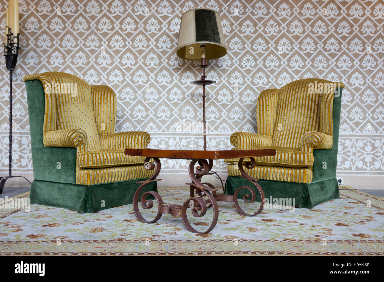 Cosy waiting room with two green and yellow velvet wing chairs in Parador Plasencia (Extremadura, Spain). Stock Photo