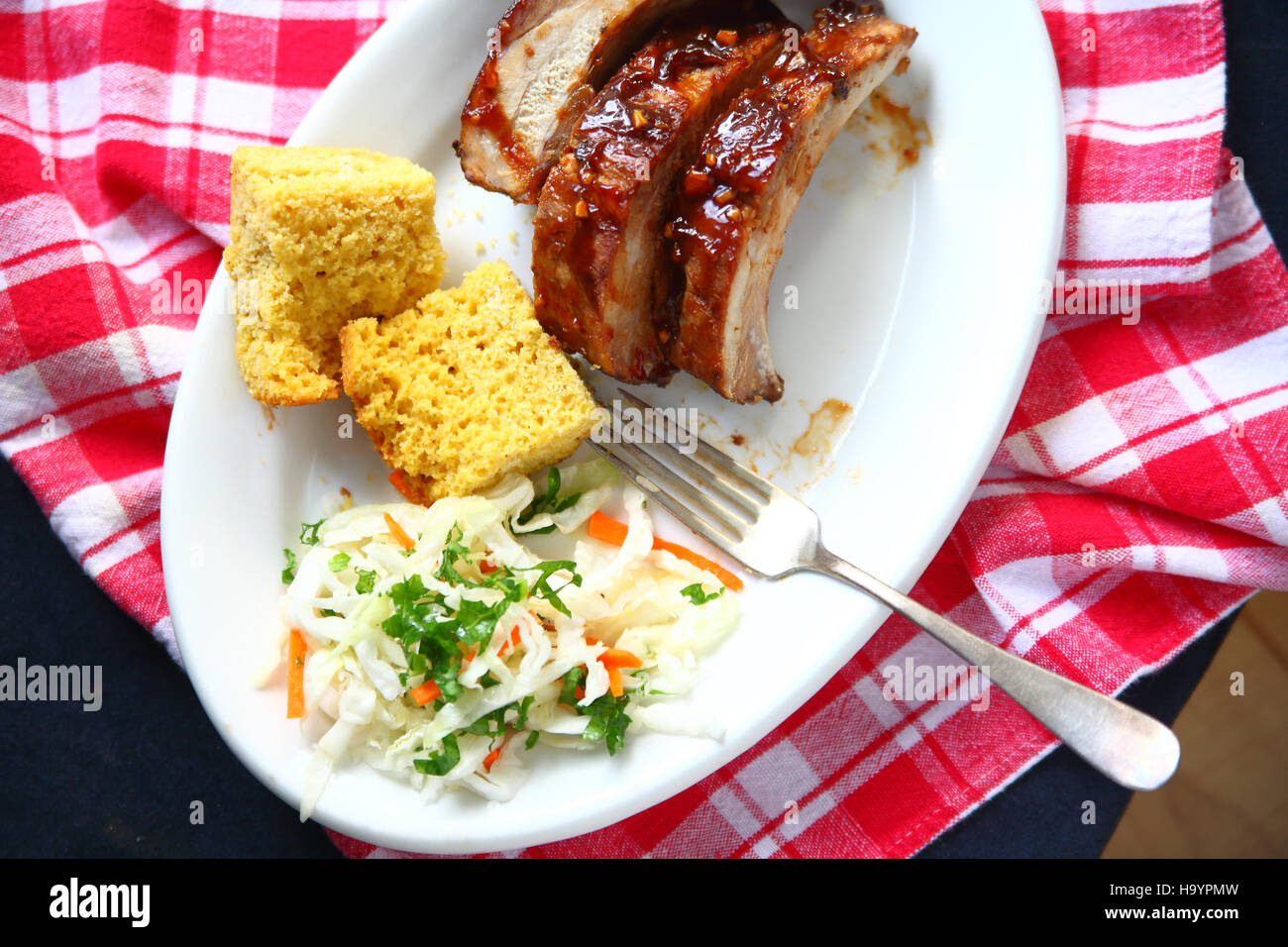 Meal of baby back ribs with garlic barbecue sauce, cornbread and