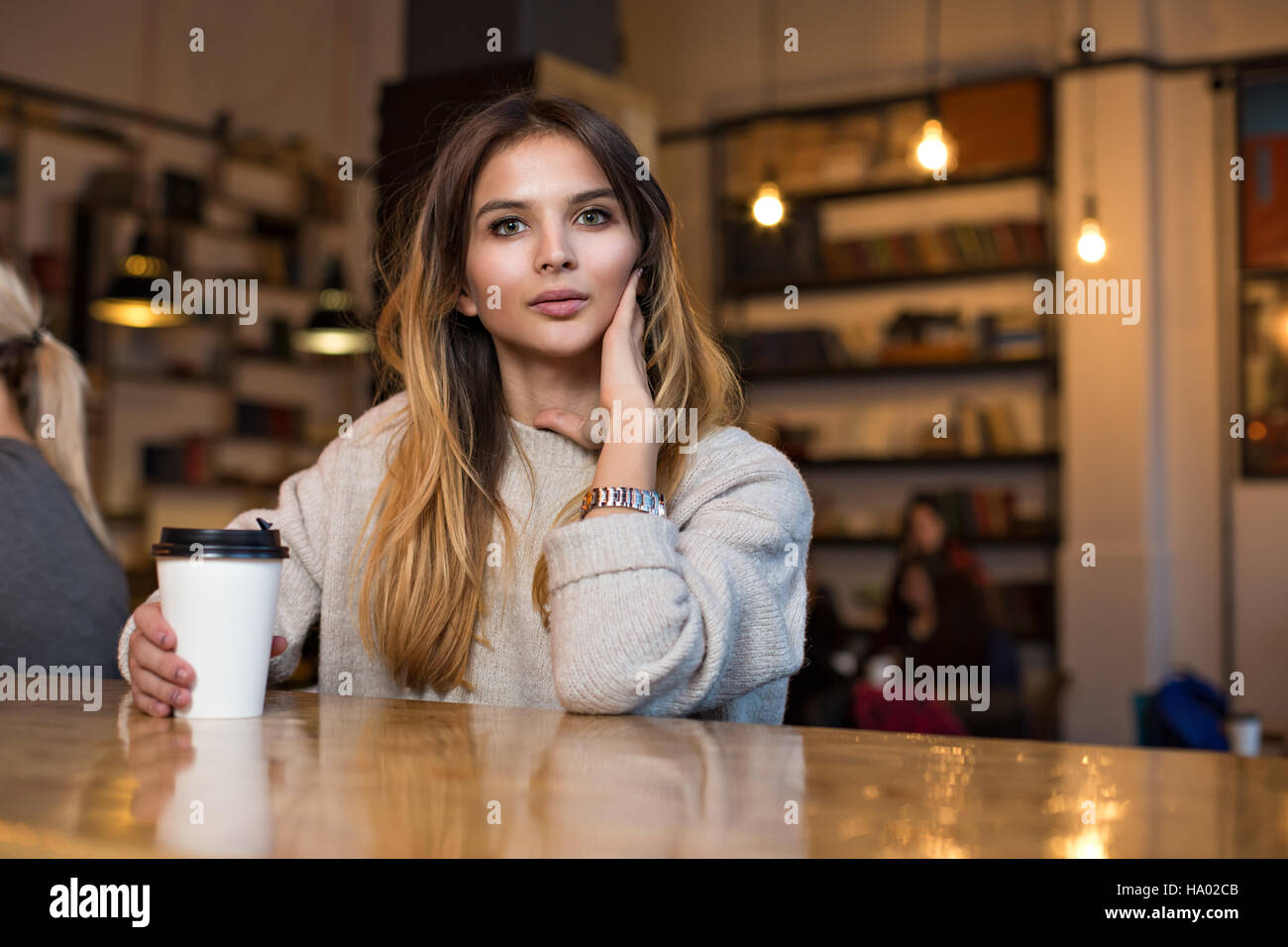 Young charming woman while sitting alone in coffee shop during free