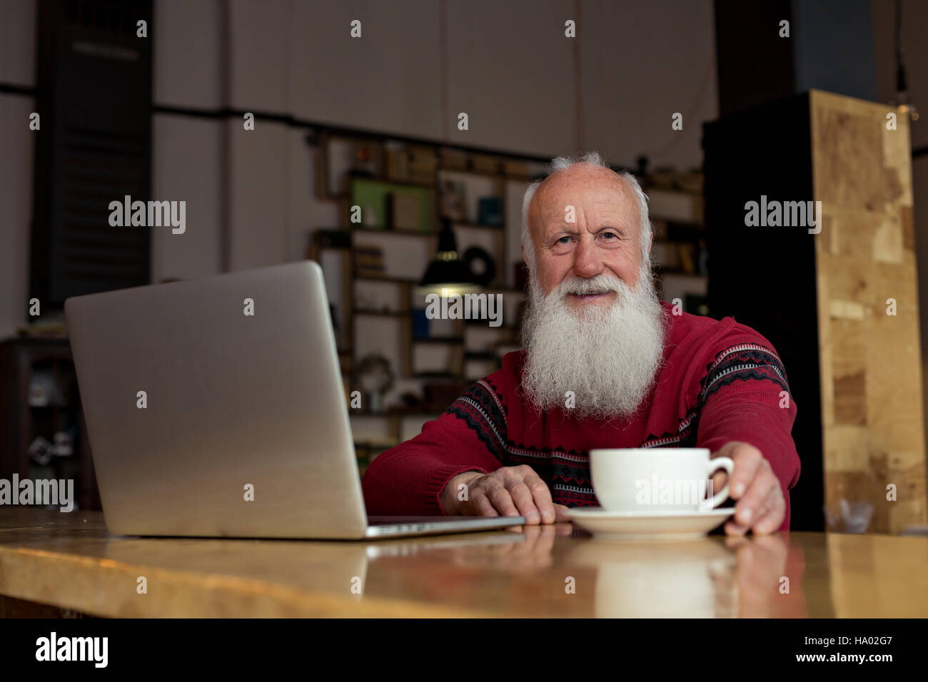 old man with a laptop in a cafe Stock Photo