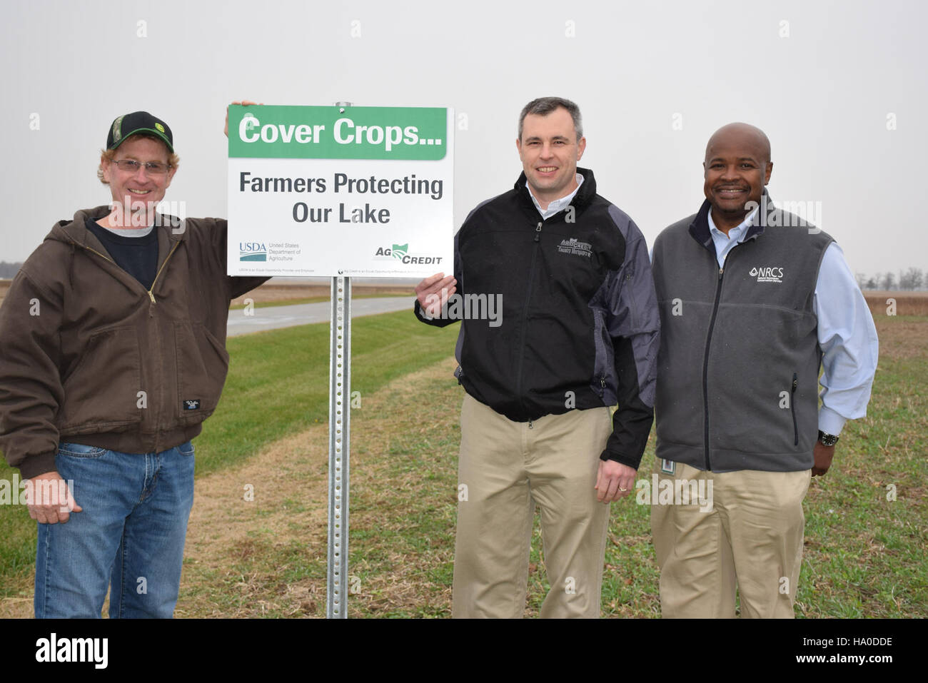 usdagov 15848539410 Hardin County farmer Jerry McBride, AgCredit CEO Brian Ricker and Ohio State Conservationist Terry Cosby place the first cover crop sign Stock Photo