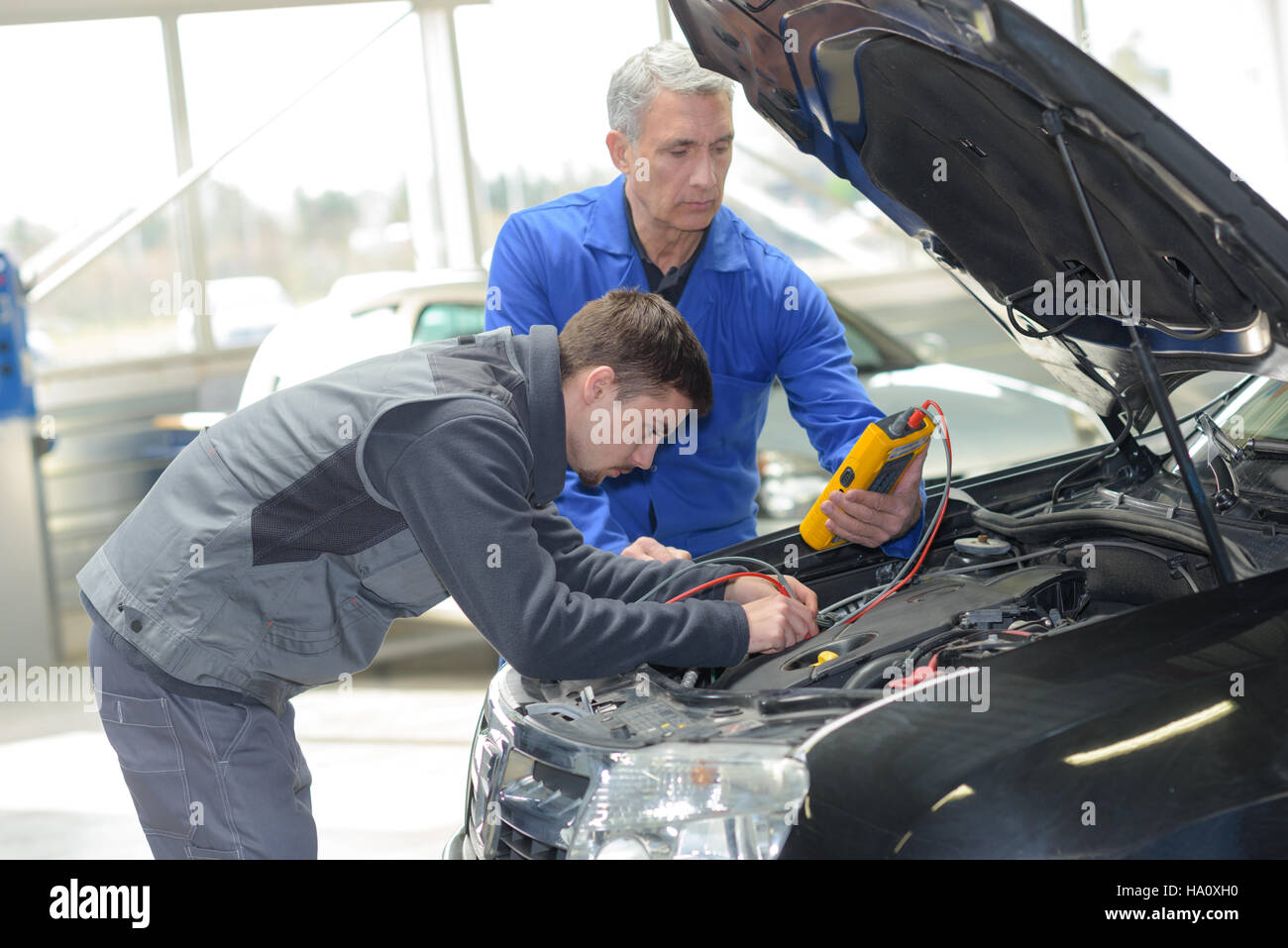 auto mechanic teacher and trainee performing tests at mechanic school