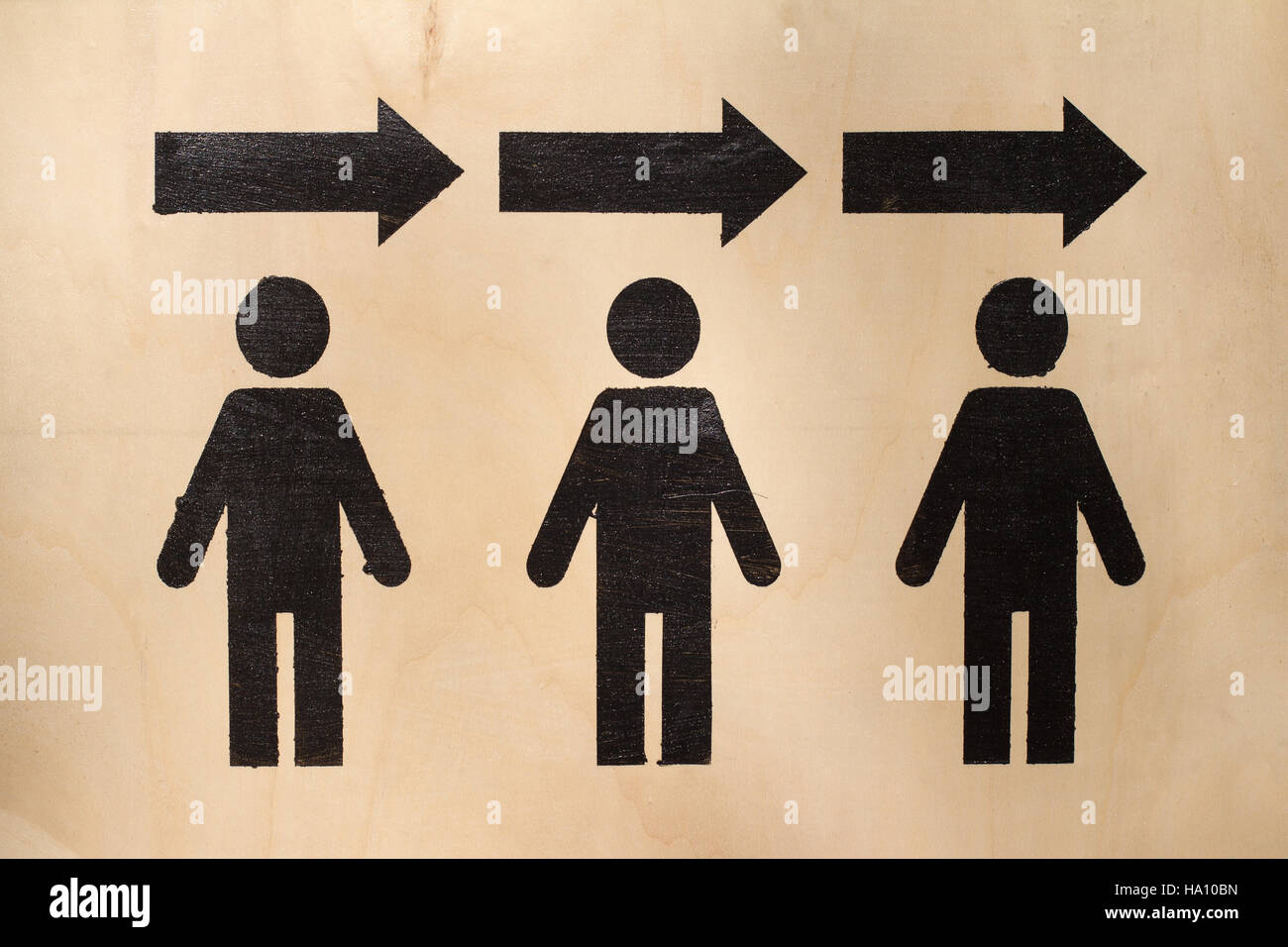 exit symbol with three human black icons with arrows above them on wood texture Stock Photo