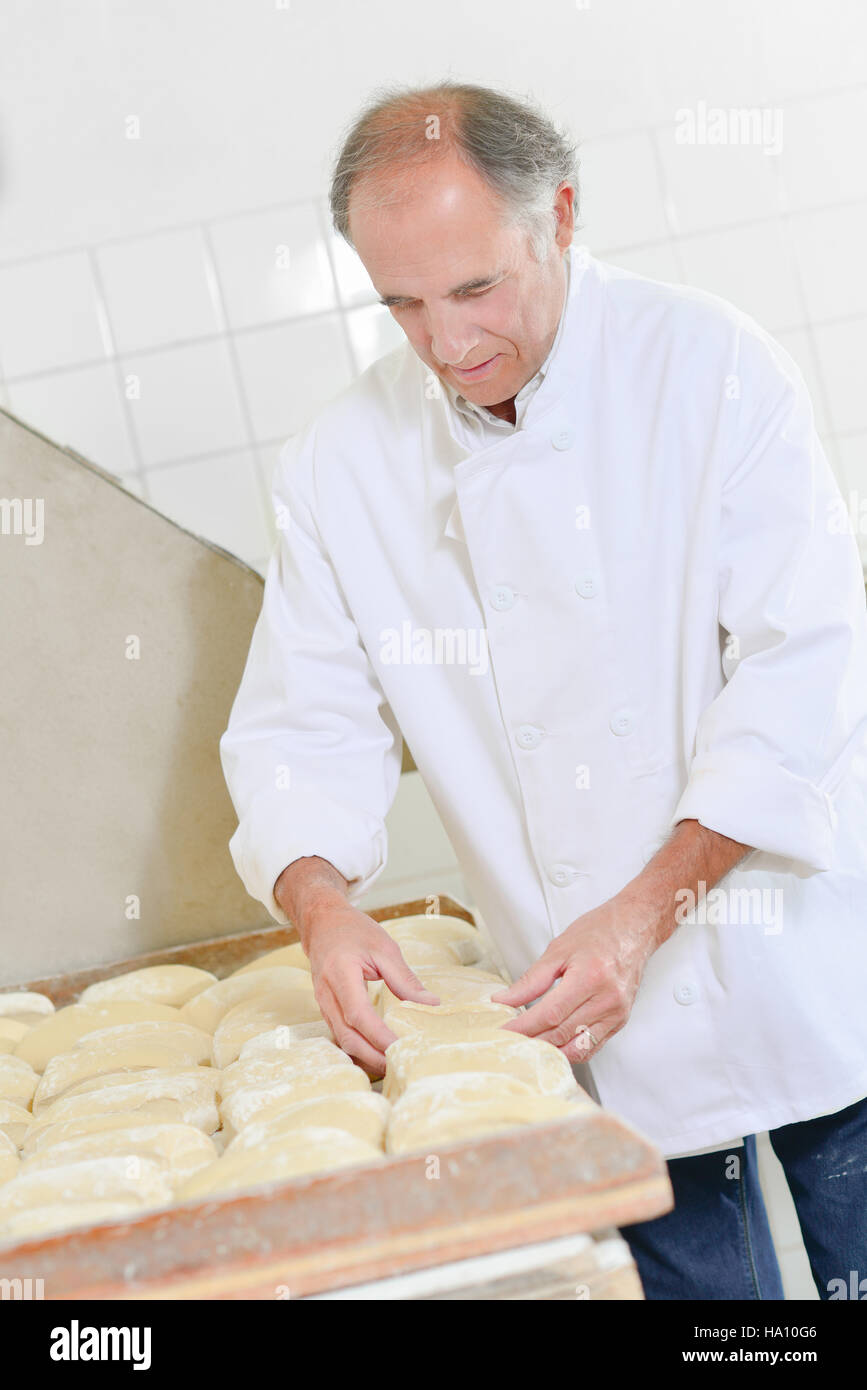 Baker preparing loaves of bread Stock Photo