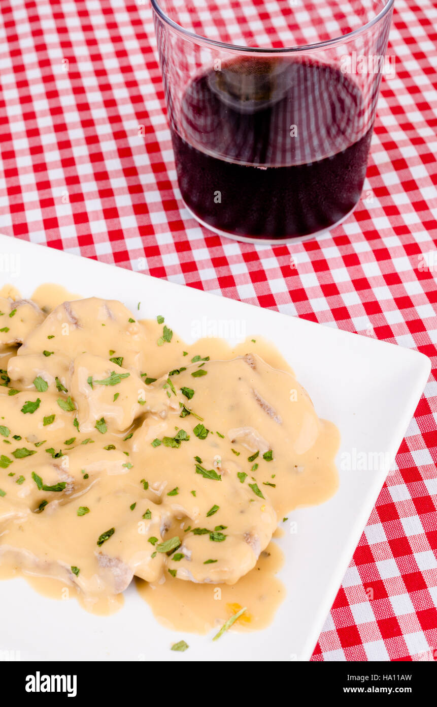 Traditional Spanish pork loin tapa in pepper sauce served with red wine