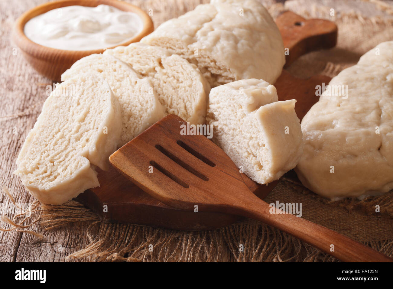 Fresh sliced yeast knedliks and sour cream close-up on the table. horizontal Stock Photo