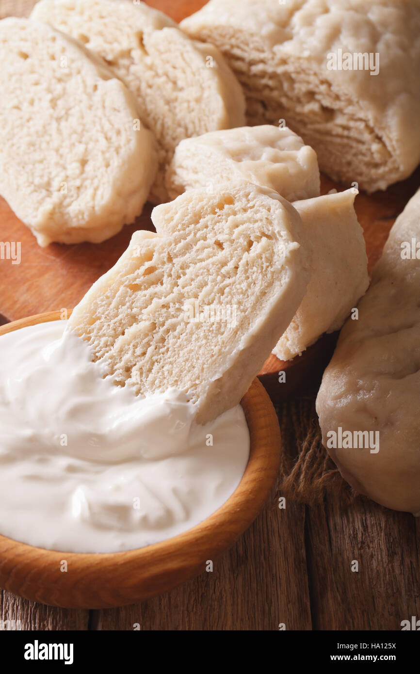 Czech boiled knedliks with sour cream macro on the table. vertical Stock Photo