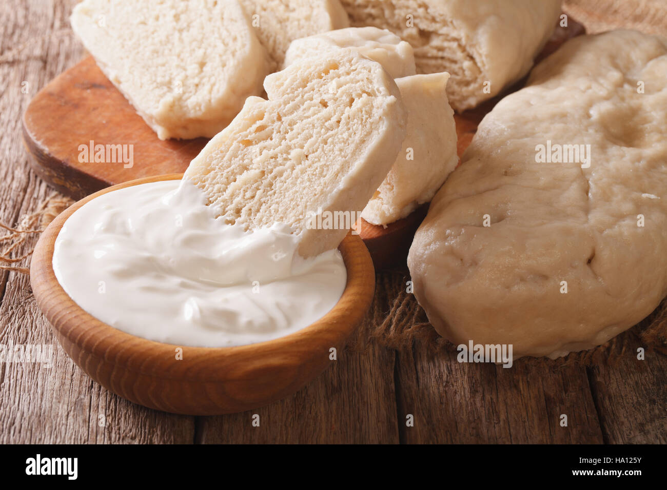 Czech boiled knedliks with sour cream macro on the table. Horizontal Stock Photo