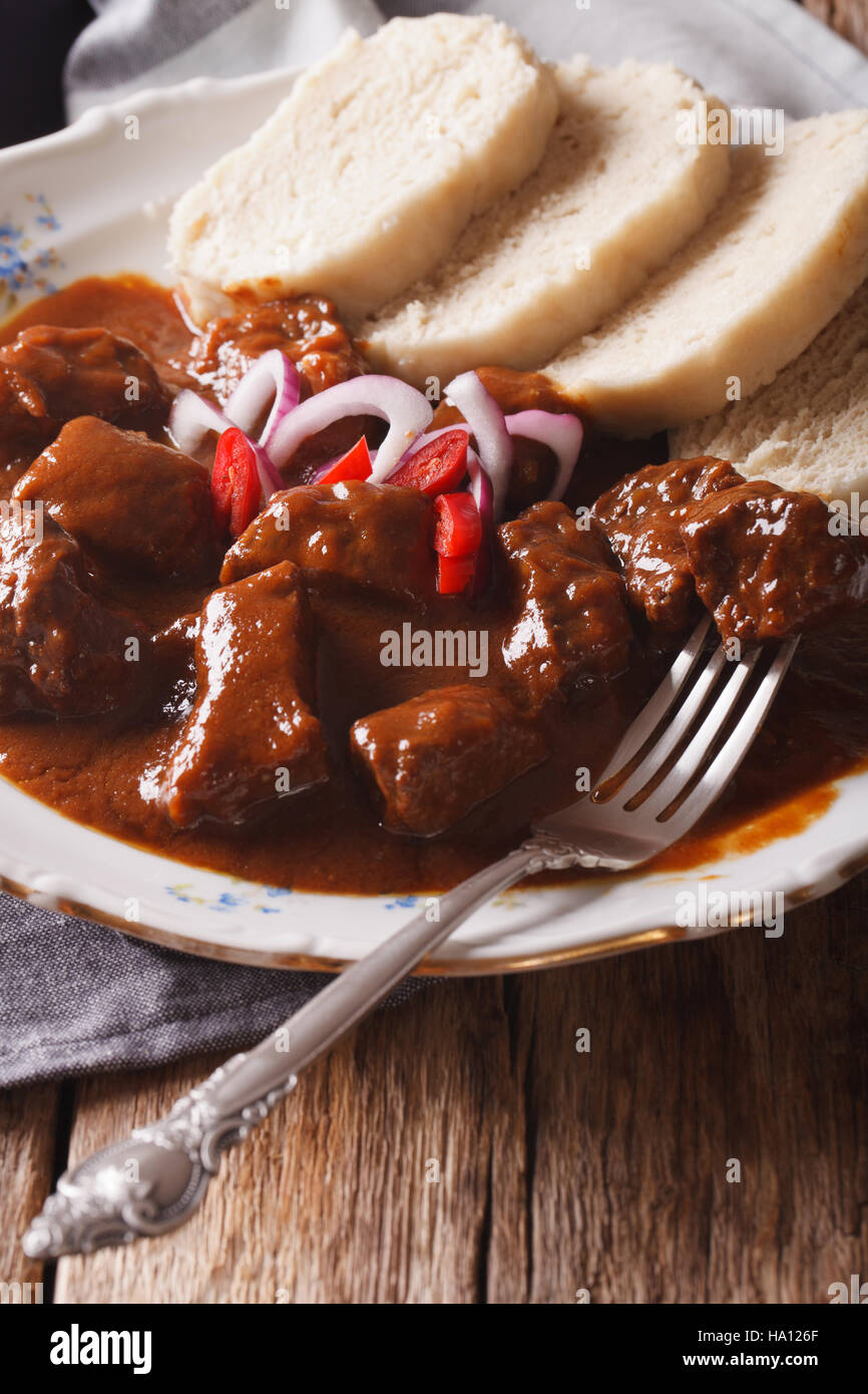homemade hot Czech goulash with knodel in a plate close-up. vertical Stock Photo