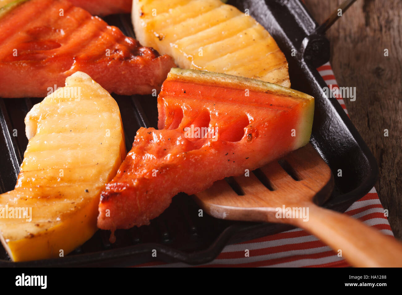 Watermelon and melon in a pan grill macro on the table. Horizontal Stock Photo