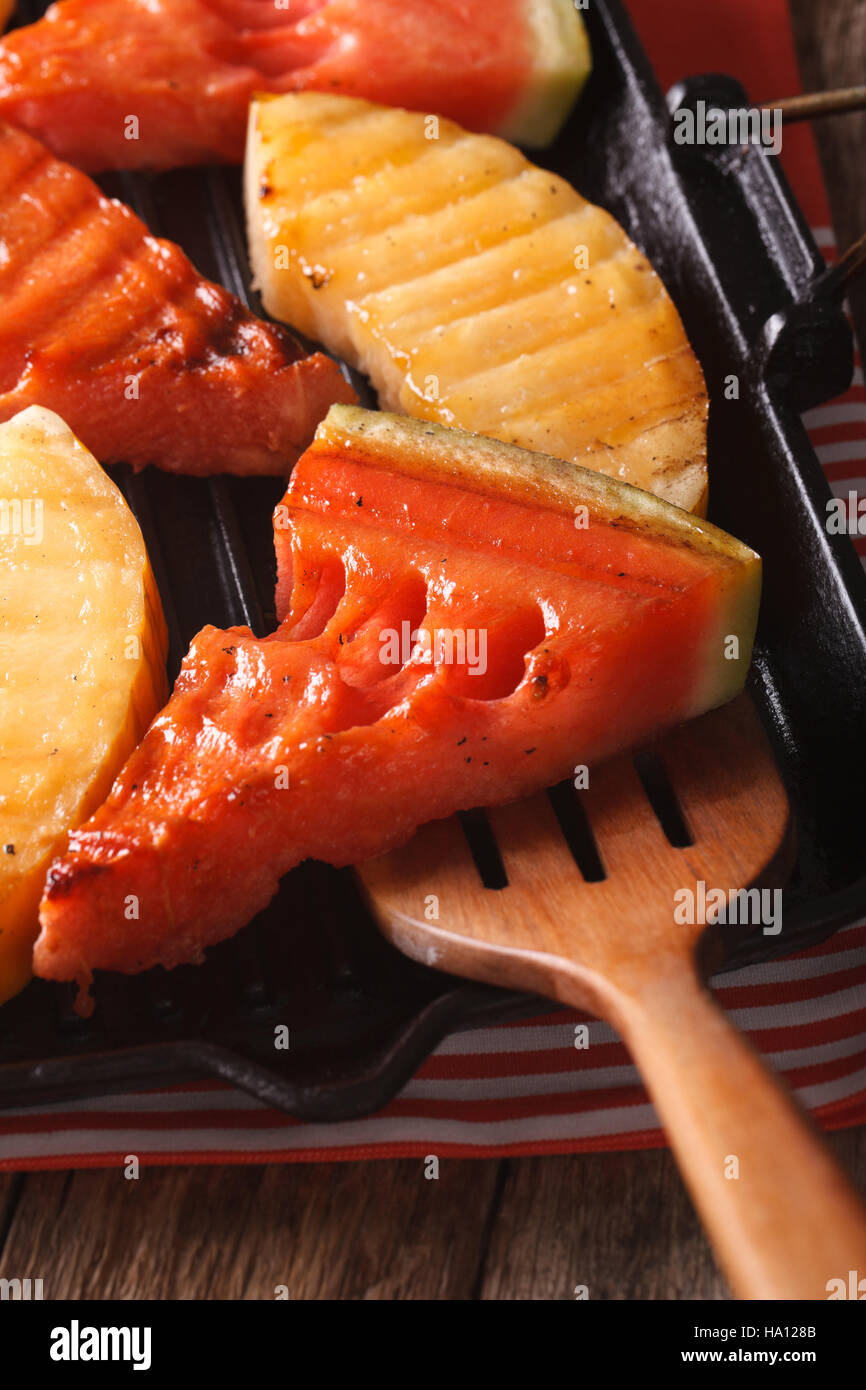 Watermelon and melon in a pan grill close-up on the table. vertical Stock Photo