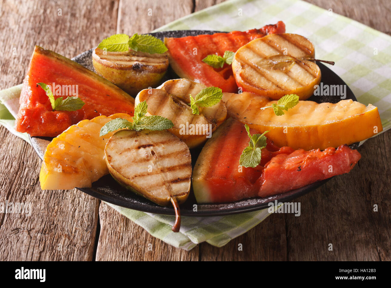 fruits grilled with mint close up on a plate on the table. horizontal Stock Photo