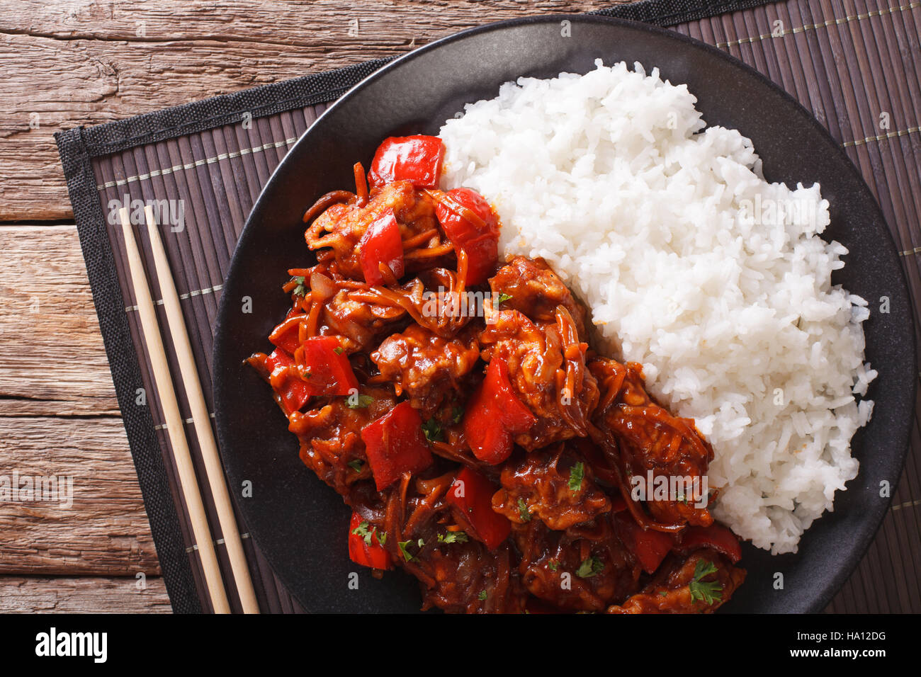 Rice with stewed pork in sweet and sour sauce on the plate closeup ...