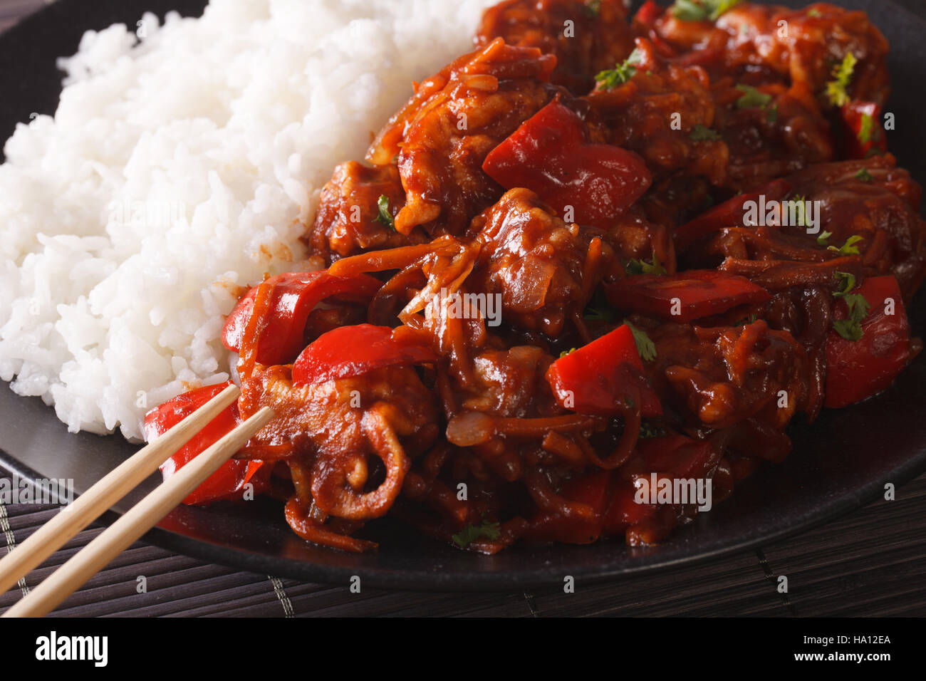 Rice with stewed pork in sweet and sour sauce on the plate closeup ...