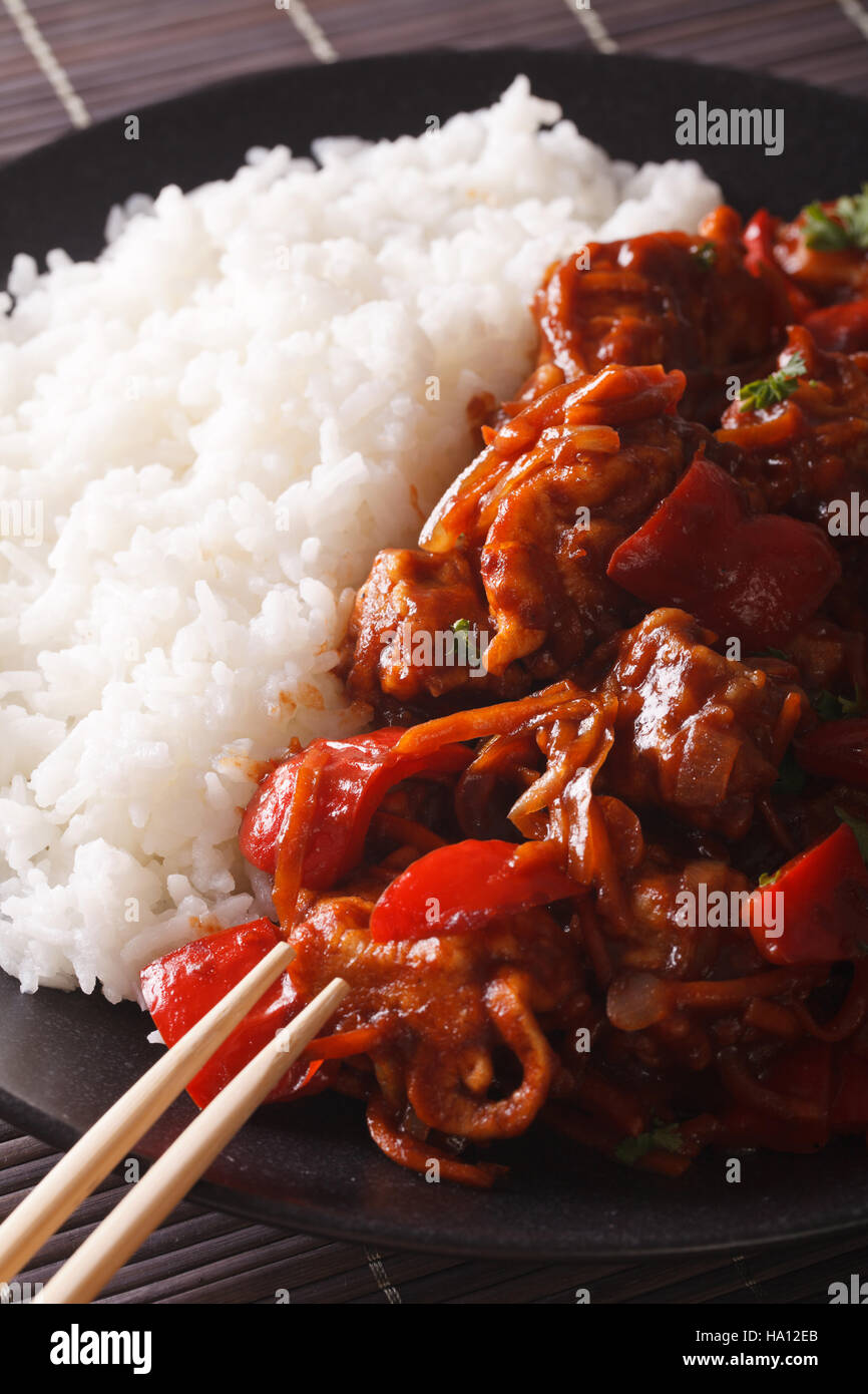 Rice with stewed pork in sweet and sour sauce on the plate closeup ...