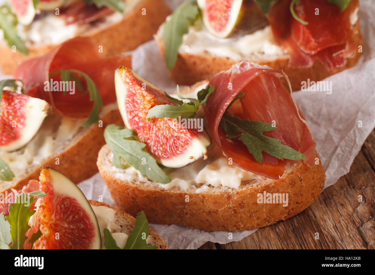 homemade sandwiches with figs, ham, arugula and cream cheese close-up on the table. horizontal Stock Photo
