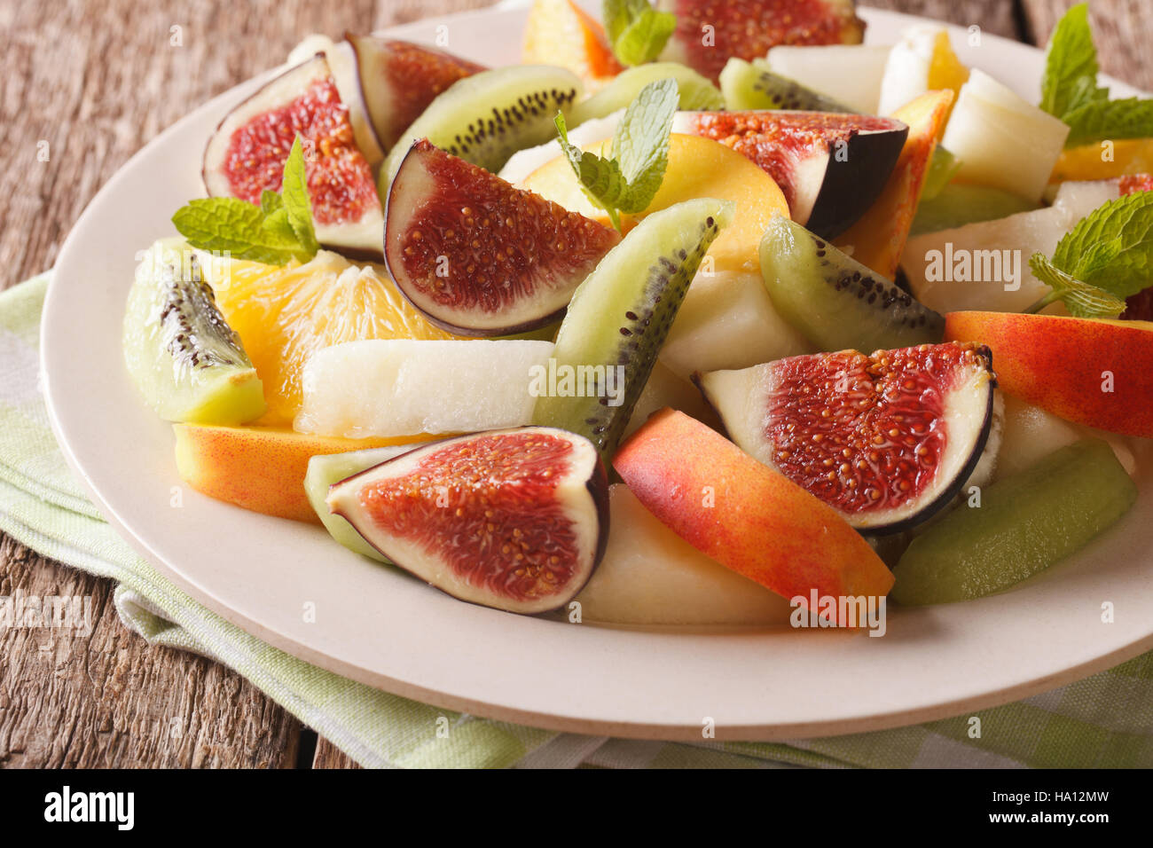 Delicious sliced fruit fig, peach, melon, kiwi and orange close-up on the table. horizontal Stock Photo