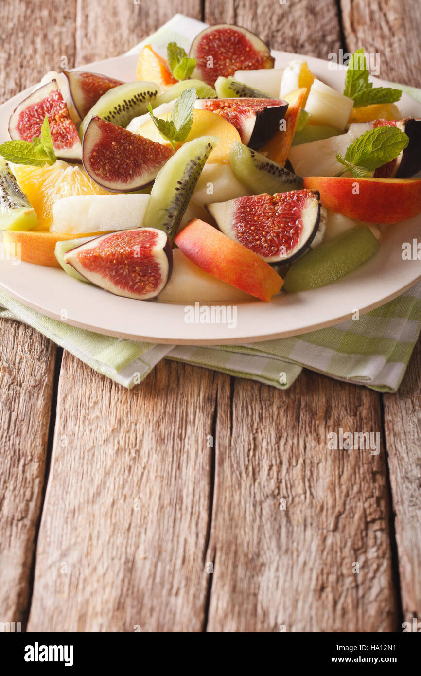 Fruit mix of fig, peach, melon, kiwi and orange close-up on the table. vertical Stock Photo