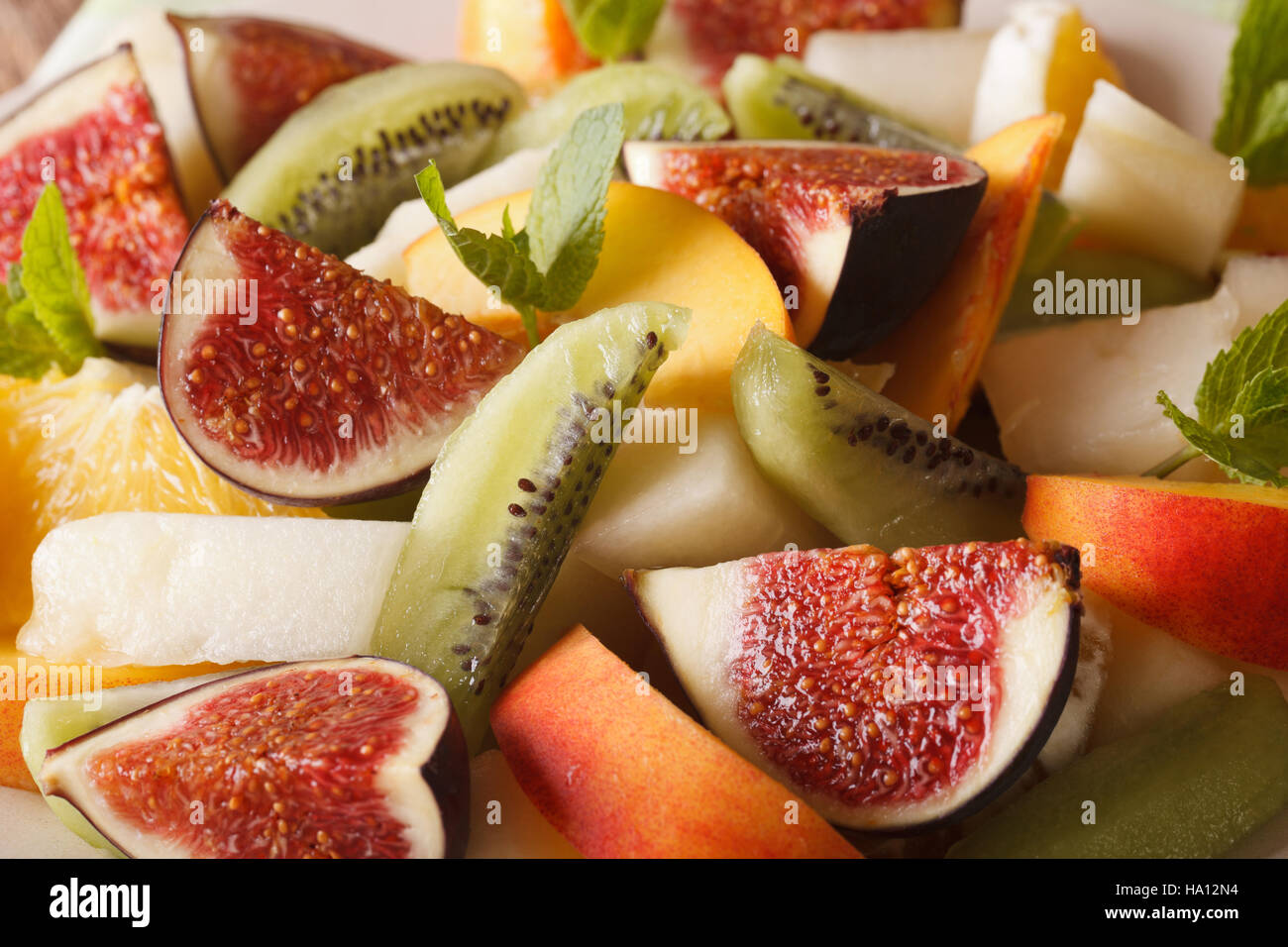 Background of sliced fresh fruit: figs, peaches, melons, kiwi and orange macro. horizontal Stock Photo