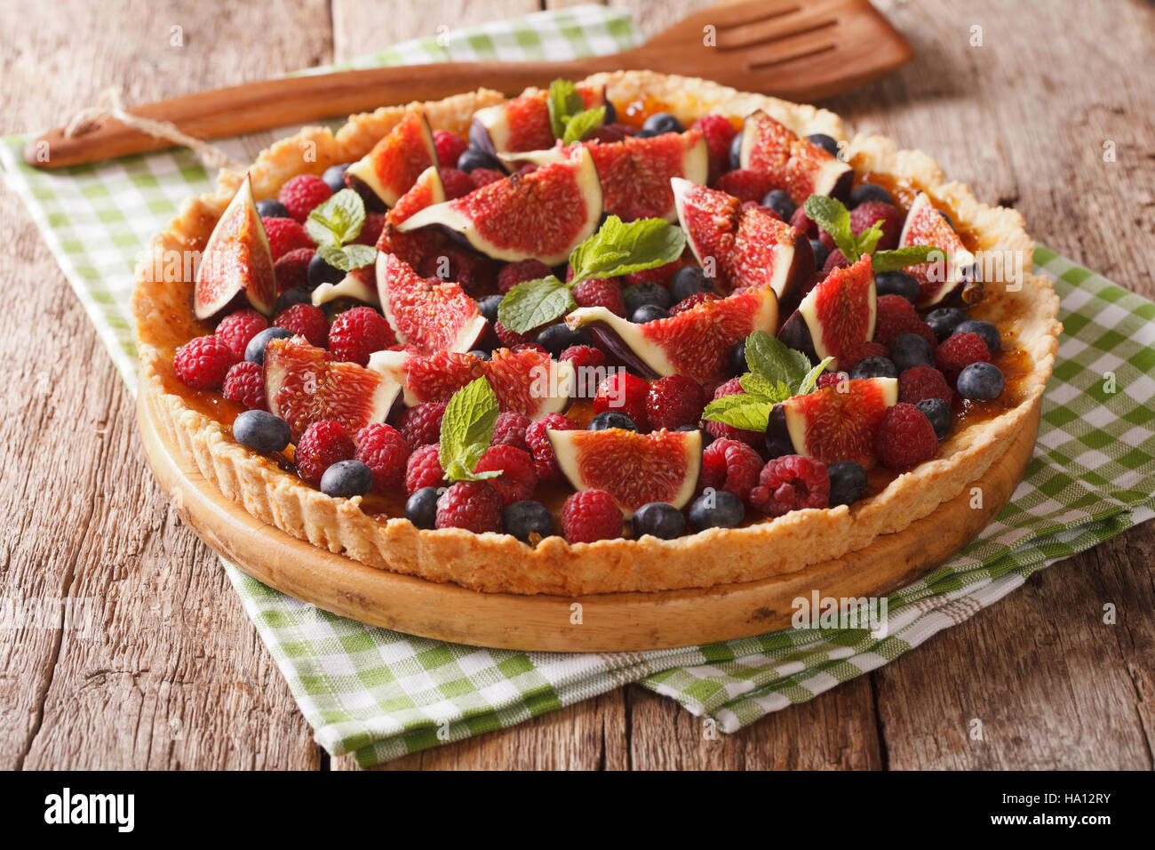 homemade tart with fresh fruits and berries decorated with mint close up on the table. horizontal Stock Photo