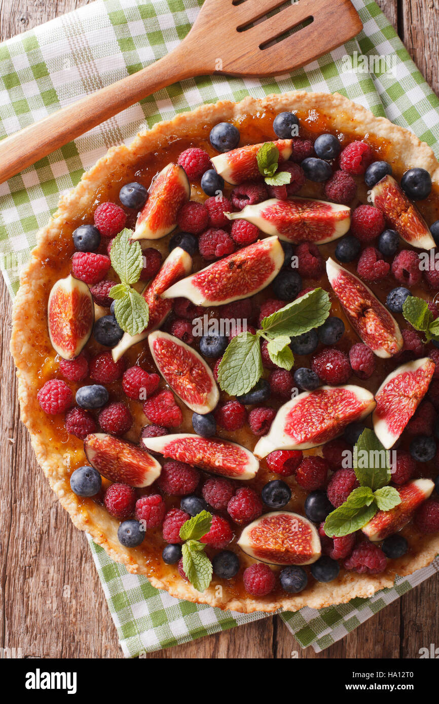 Delicious tart with fresh fruit and berries close up on the table. vertical view from above Stock Photo