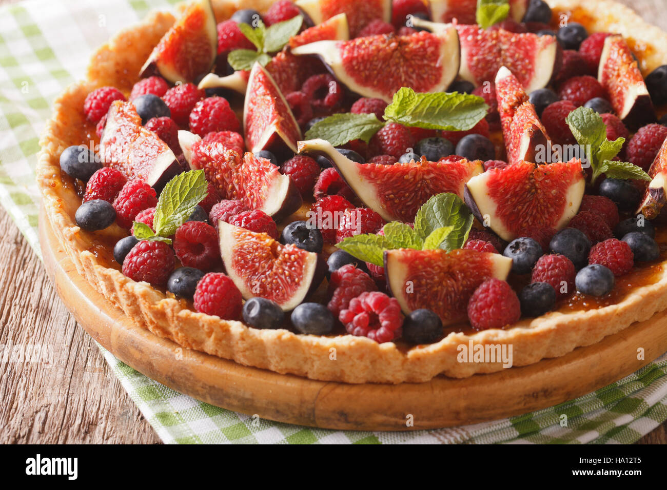 Summer cake with fresh figs, raspberries and blueberries close-up on the table. horizontal Stock Photo