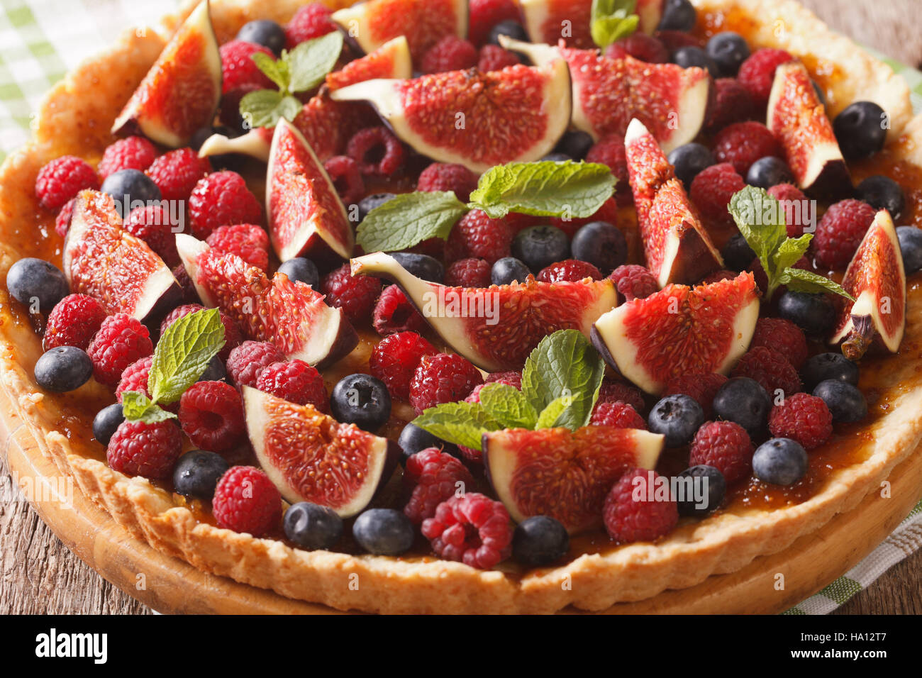 Freshly baked cake with fresh figs, raspberries and blueberries macro on the table. horizontal Stock Photo