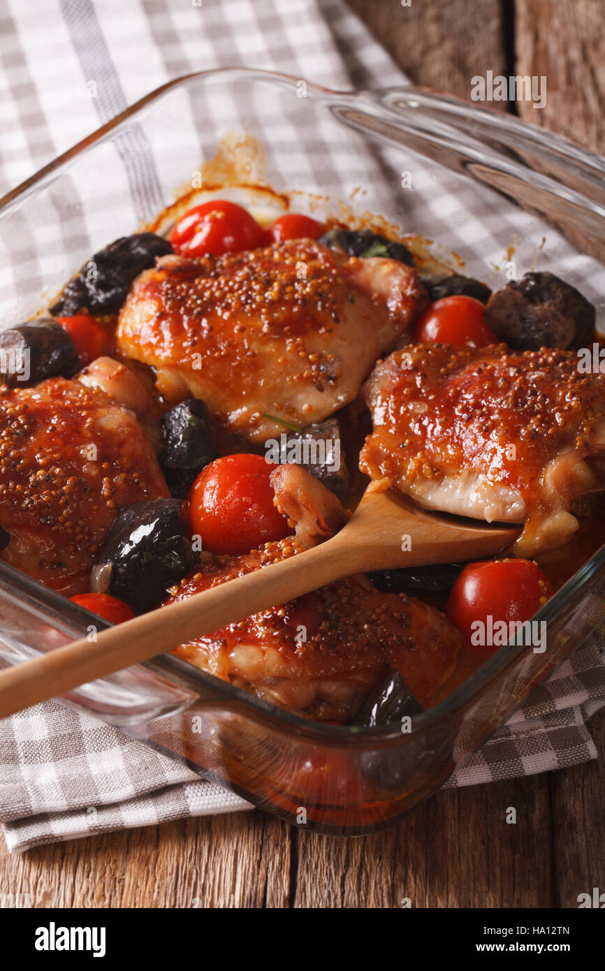 chicken thigh baked with tomatoes and cep mushrooms close up in baking dish on the table. vertical Stock Photo